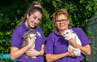 2 members of staff holding rabbits 