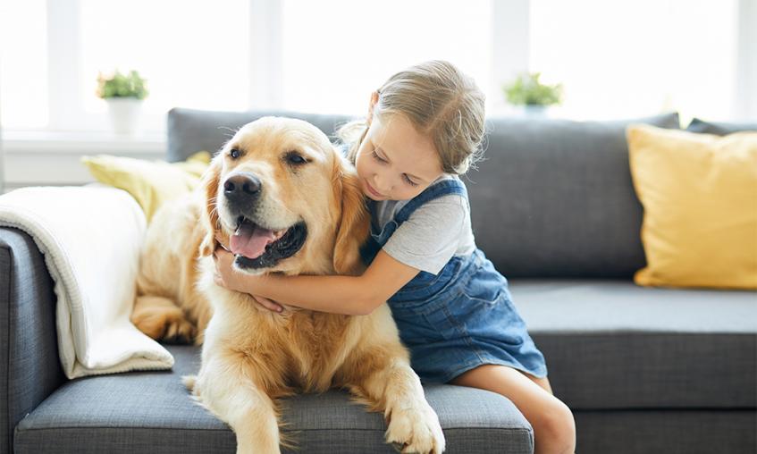 Young child hugging dog