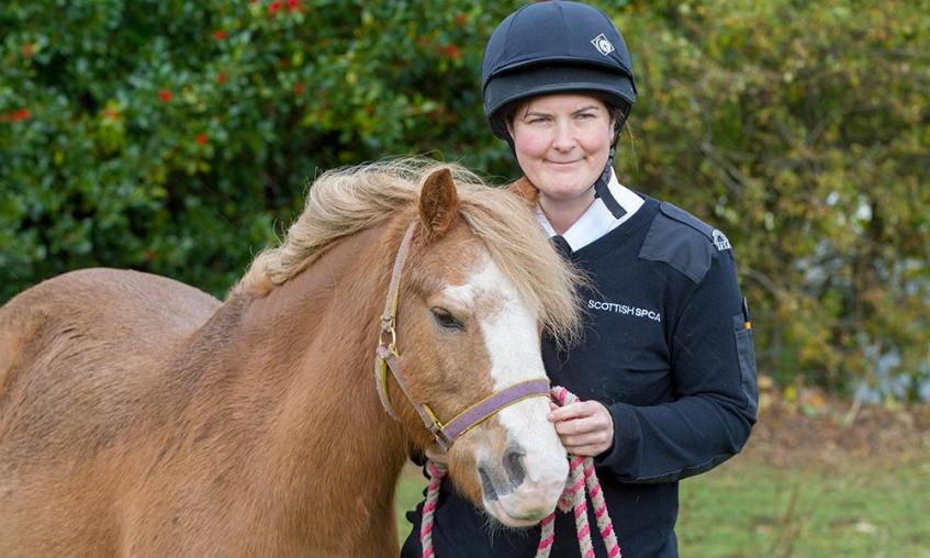 SSPCA officer standing next to a pony
