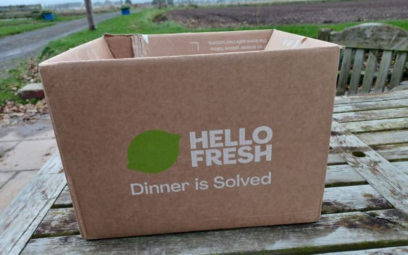 A Hello Fresh box sitting on a wooden surface outdoors