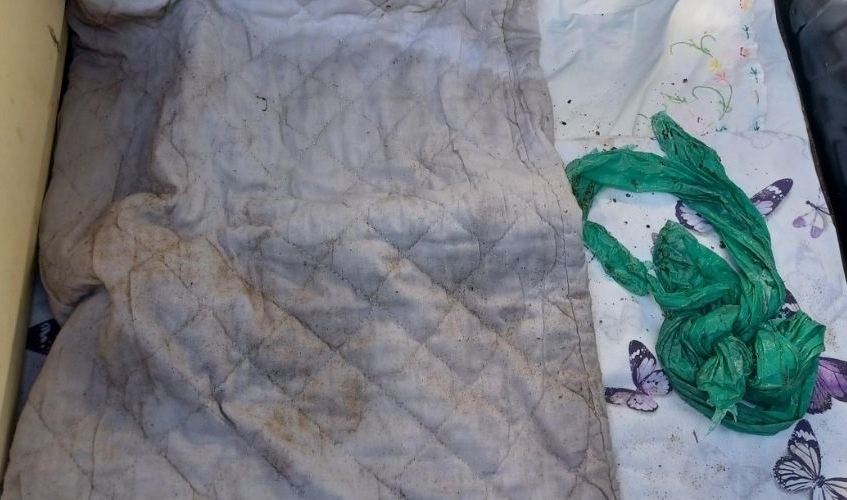 a quilted pillowcase with the remains of a green refuse sack next to it