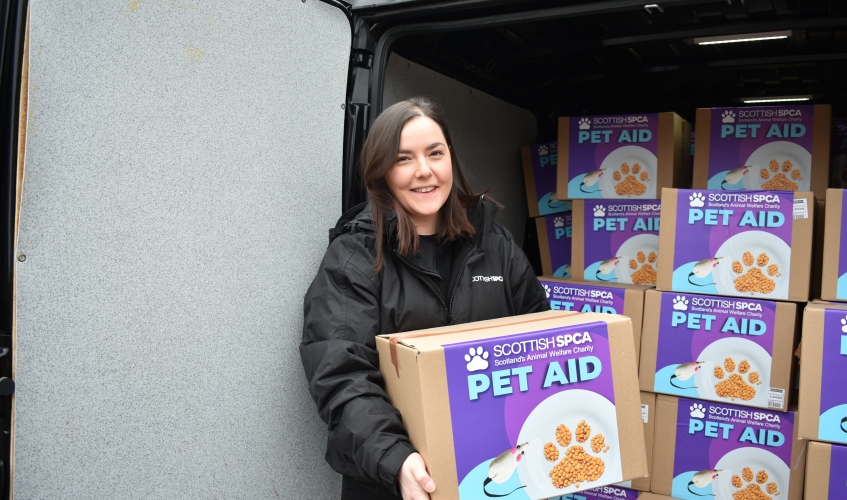 Carrie lifting pet aid donation boxes from the back of a van
