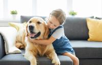 Young child hugging dog
